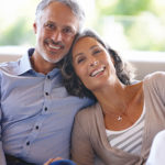 Couple smiling and relaxing on couch